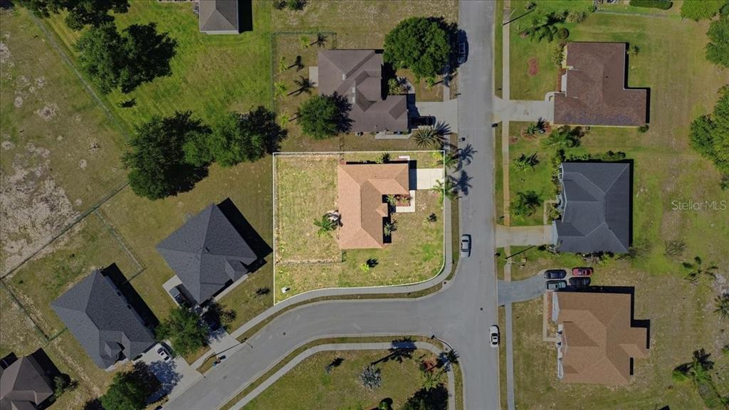 An aerial view shows a single-story house with a tan roof on a corner lot — 4378 DINNER LAKE BOULEVARD, LAKE WALES, FL