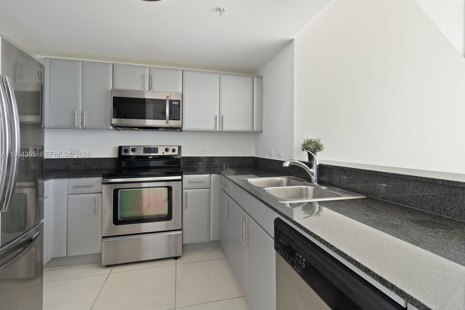 A kitchen features gray cabinets, stainless steel appliances, and dark granite countertops — 1861 NW North River Dr # 3, Miami FL 33125, MIAMI, FL