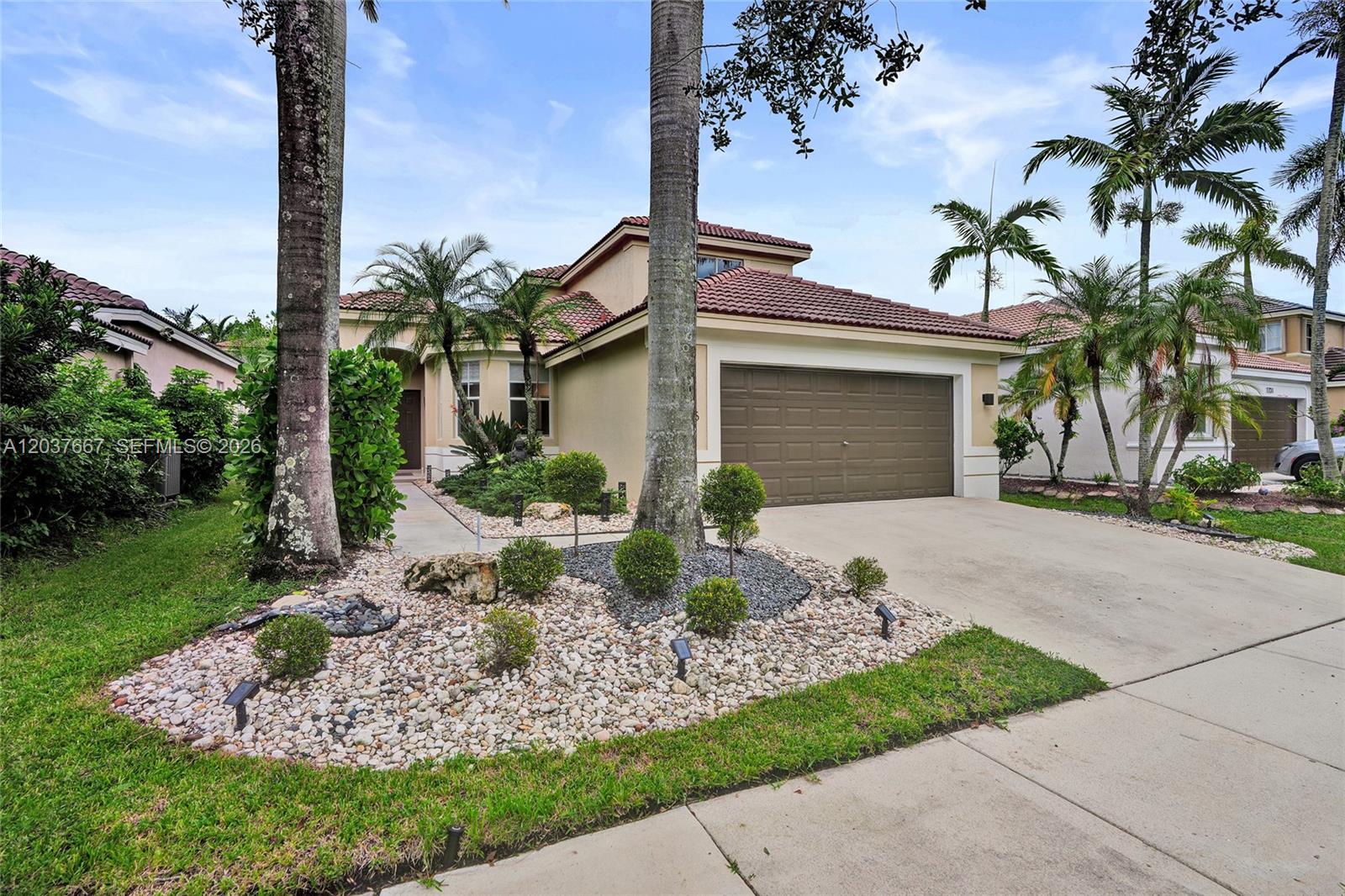 A two-story house with a brown garage door, tiled roof, and landscaped front yard — 1725 Winterberry Ln, Weston FL 33327, WESTON, FL