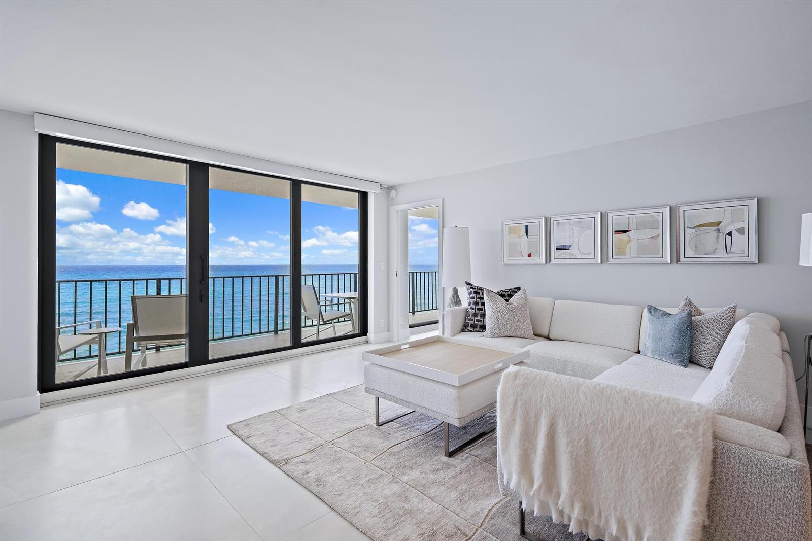 A bright living room features a white sectional sofa, a coffee table, and ocean views — 3456 S Ocean Boulevard # 701, Palm Beach FL 33480, PALM BEACH, FL