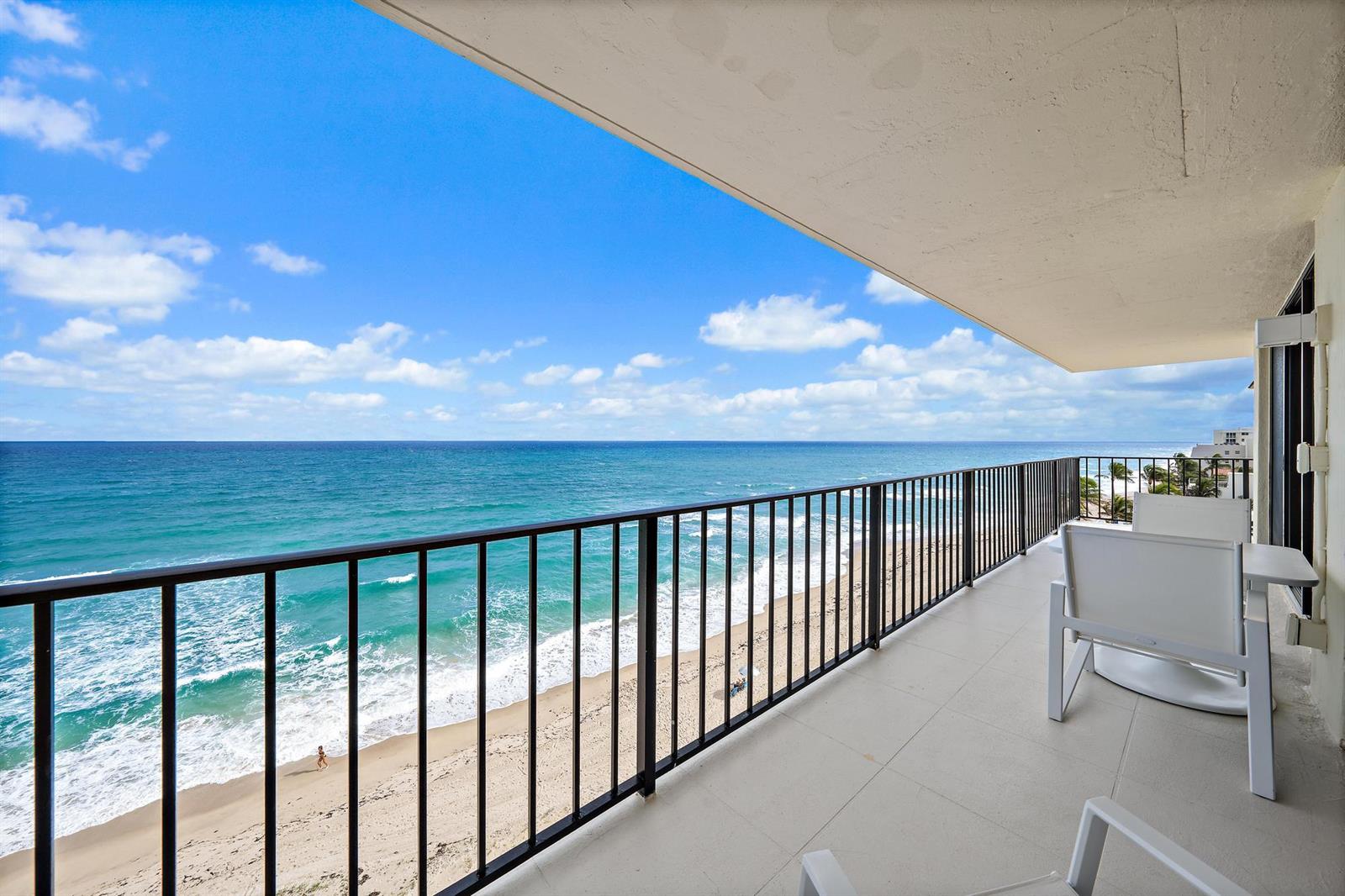 A balcony with a black metal railing overlooks a sandy beach and the ocean — 3456 S Ocean Boulevard # 701, Palm Beach FL 33480, PALM BEACH, FL