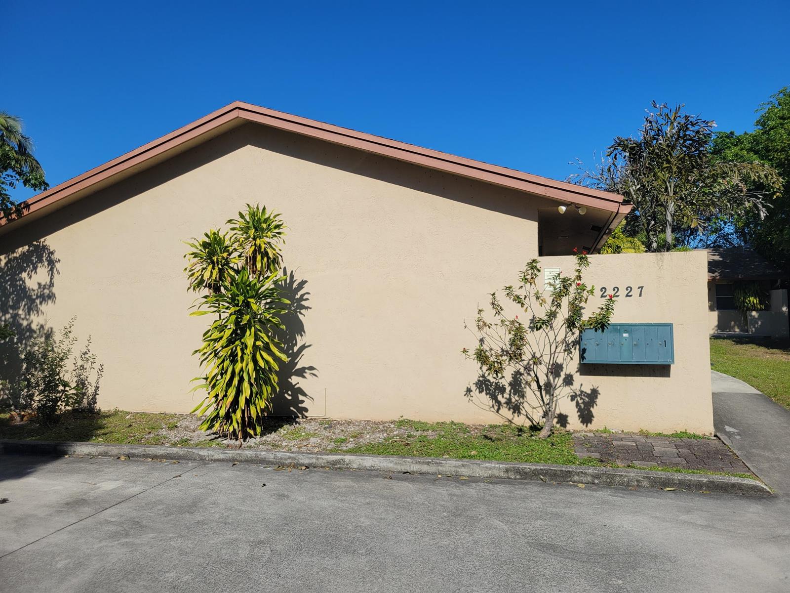 A beige exterior wall of a building features a house number and a mailbox unit — 2227 Monroe Street # 2, Hollywood FL 33020, HOLLYWOOD, FL