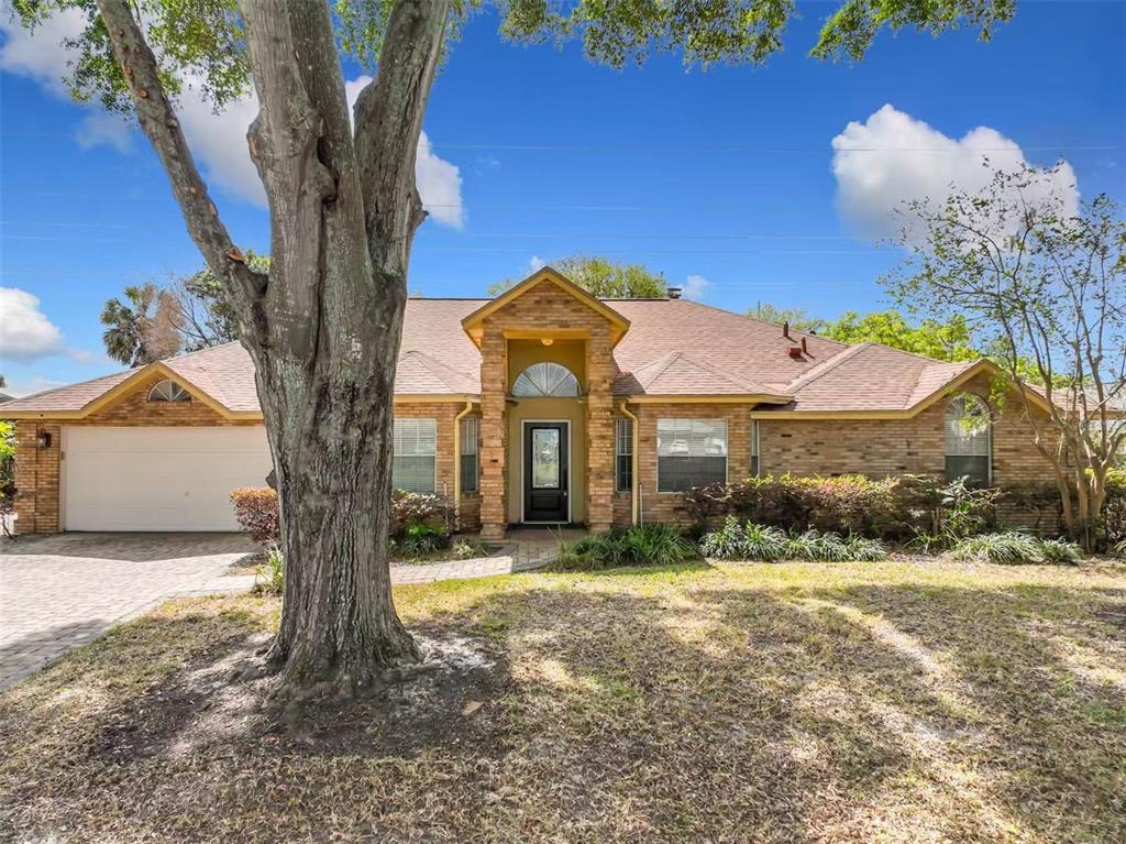 A single-story brick house with a two-car garage and a central arched entryway — 9144 GALLEON COURT, ORLANDO, FL
