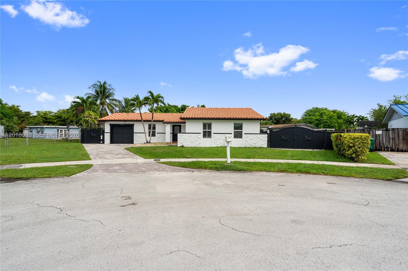 A single-story house with a white exterior, stone accents, and a red tile roof — 13611 SW 77th St, Miami FL 33183, MIAMI, FL