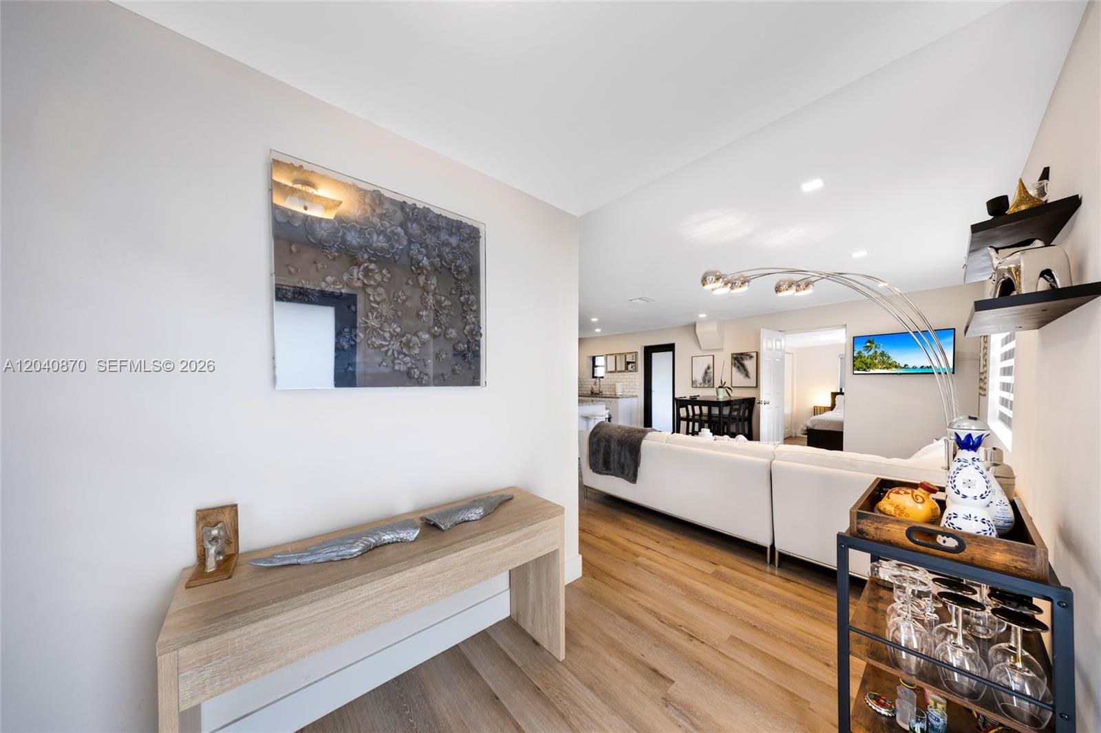 A light-wood console table sits in a hallway leading to a living room and kitchen — 5612 NW 11th Ave, Miami FL 33127, MIAMI, FL