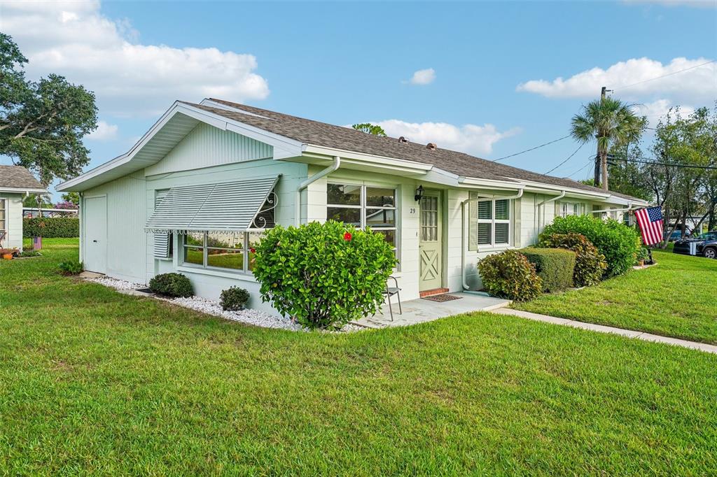 A light green, single-story residential building with a metal awning and a small front porch — 1902 DANDRIDGE STREET UNIT 29, SUN CITY CENTER, FL