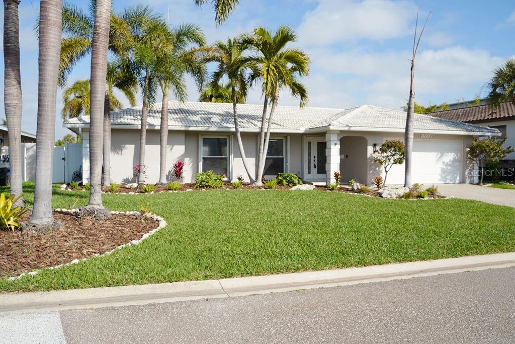A single-story house with a white tile roof, palm trees, and a green lawn — 3807 48TH AVENUE S, ST PETERSBURG, FL