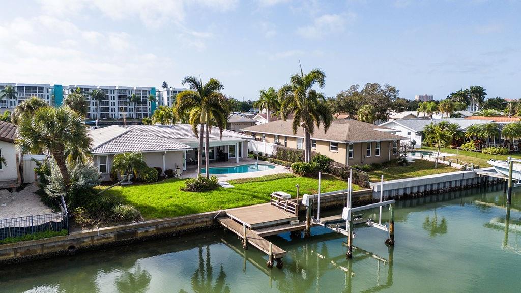 An aerial view of two waterfront houses with pools, a wooden dock, and a canal — 3807 48TH AVENUE S, ST PETERSBURG, FL