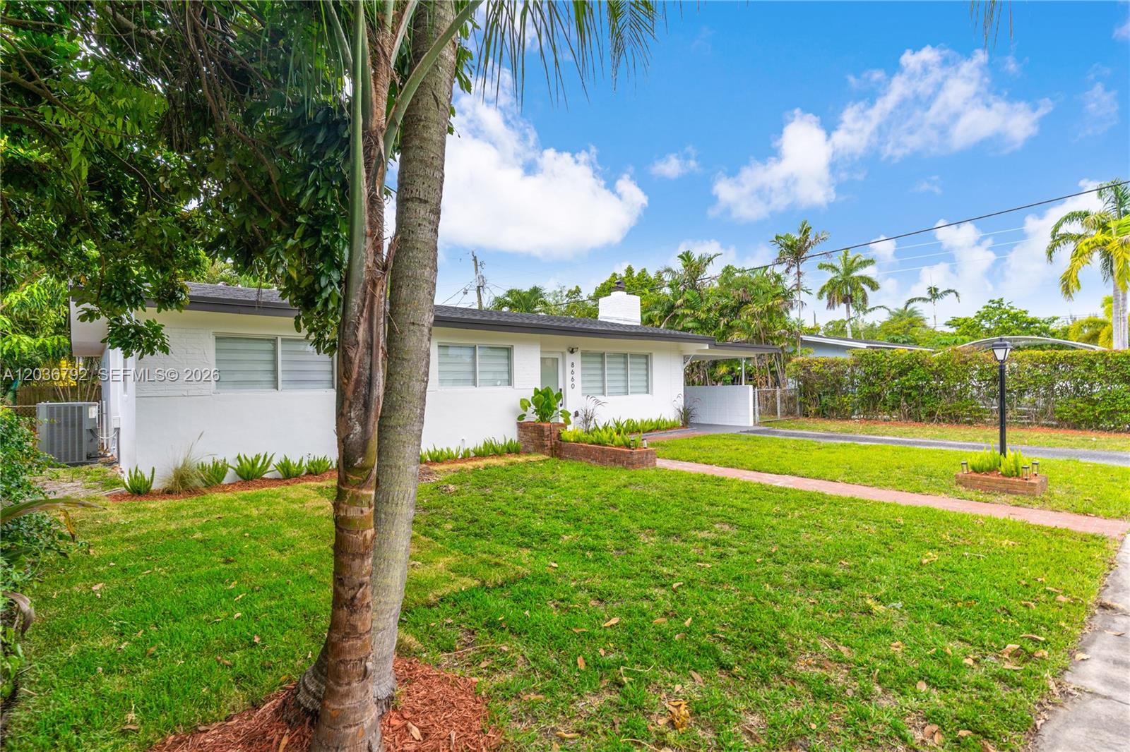 A white single-story house with a lawn, palm trees, and a brick walkway — 8660 SW 125th Ter, Miami FL 33156, MIAMI, FL