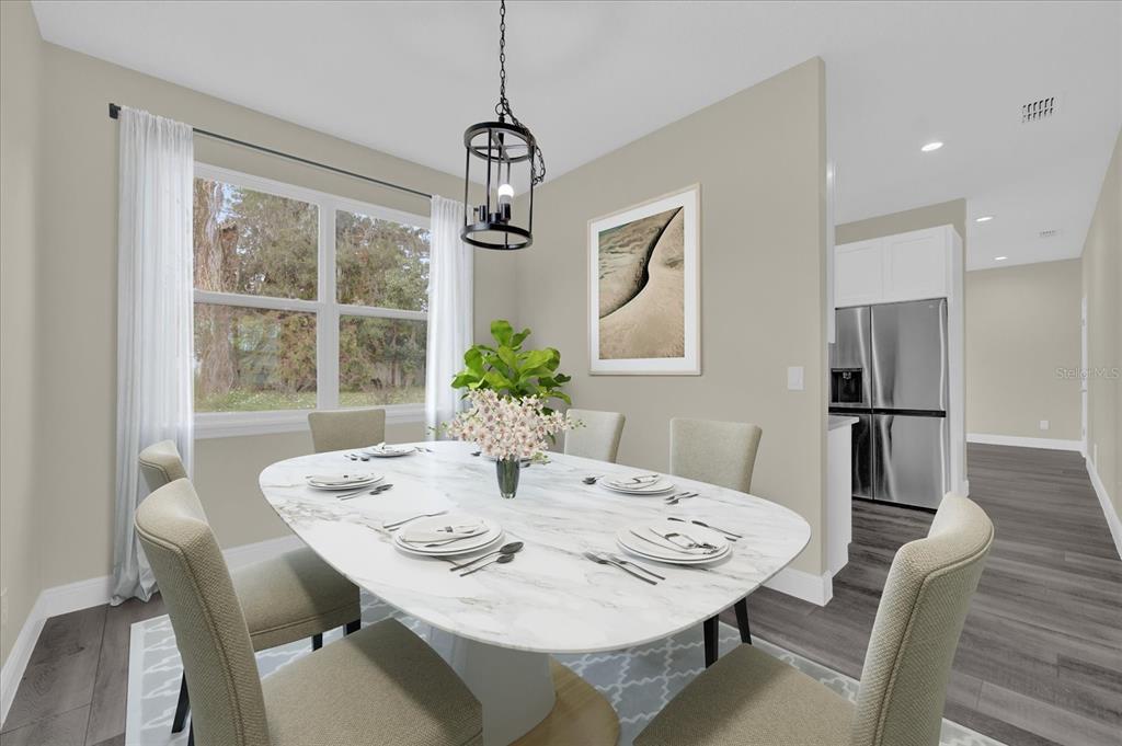 This dining room features a marble oval table, upholstered chairs, and a modern pendant light — 3778 MARTIN STREET, ORLANDO, FL