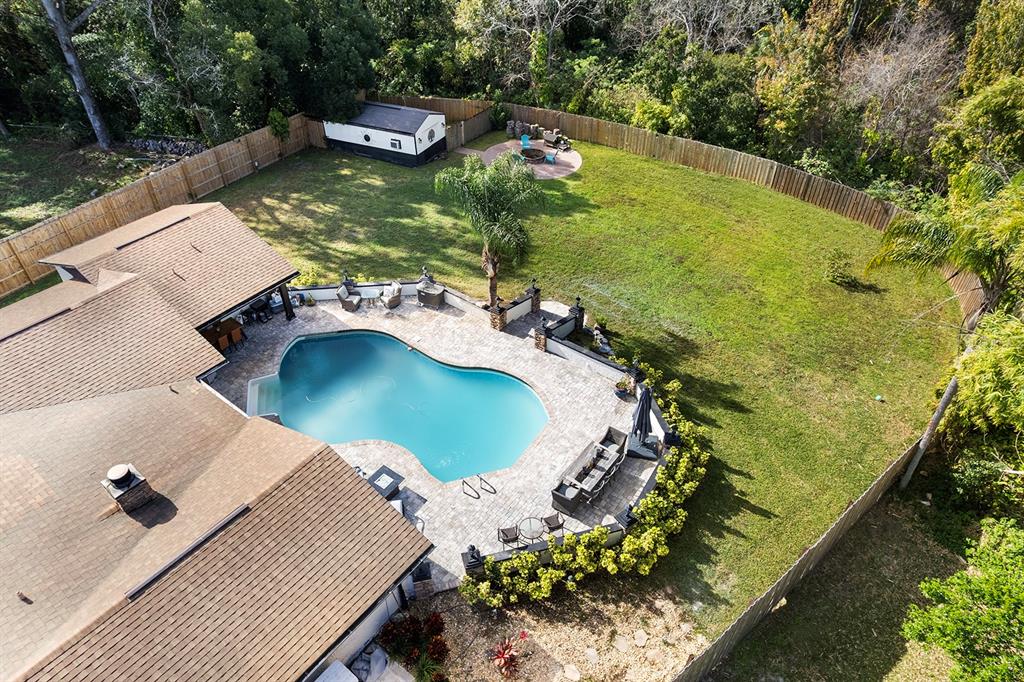 An aerial view shows a house with a swimming pool, patio, and large fenced backyard — 122 BEARSS CIRCLE, LONGWOOD, FL