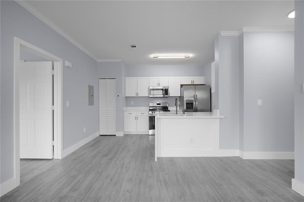 A kitchen with white cabinets, stainless steel appliances, and light gray flooring — 14340 FREDRICKSBURG DRIVE UNIT 701, ORLANDO, FL