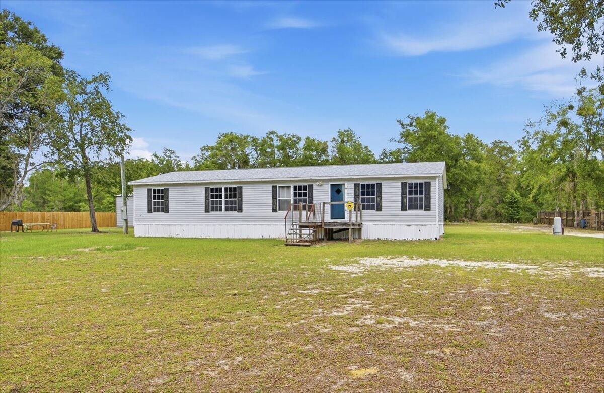 A single-story manufactured home with light gray siding sits on a large, grassy lot — 194 Keuka Road, FL 32148, FL