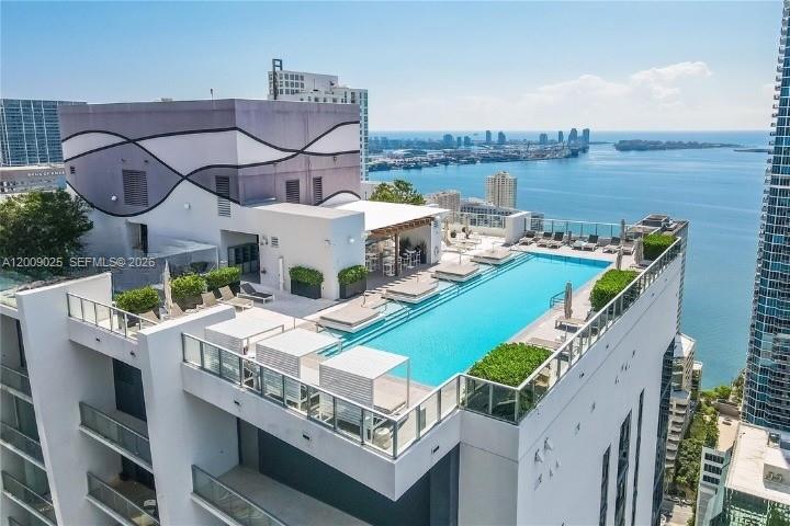 An aerial view shows a rooftop swimming pool with lounge chairs on a high-rise building — 1010 Brickell Ave # 2910, Miami FL 33131, MIAMI, FL