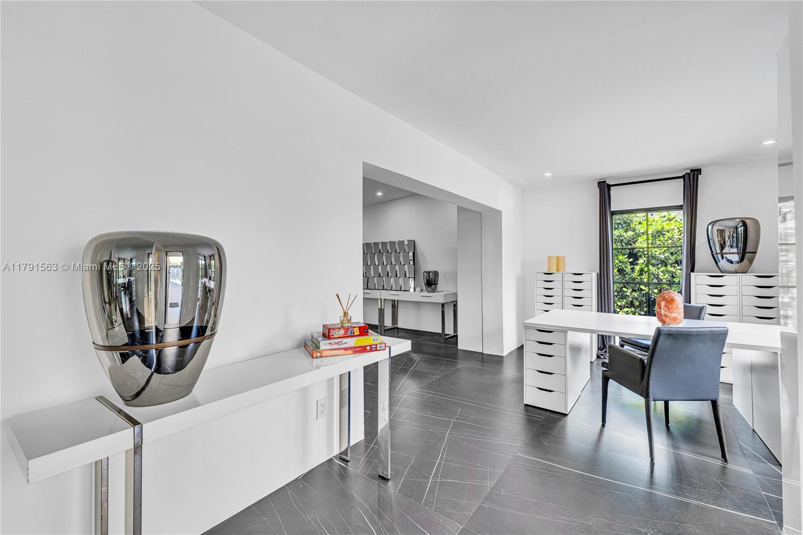 A modern home office features white desks, dark tile flooring, and a large metallic vase — 560 NW 116th Ter, Miami FL 33168, MIAMI, FL