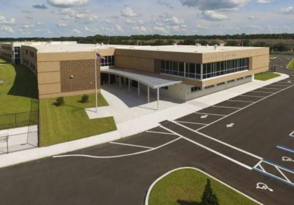An aerial view of a modern school building with a large parking lot and entrance canopy — Lot 5 138 Lane, Ocala FL 34473, OCALA, FL