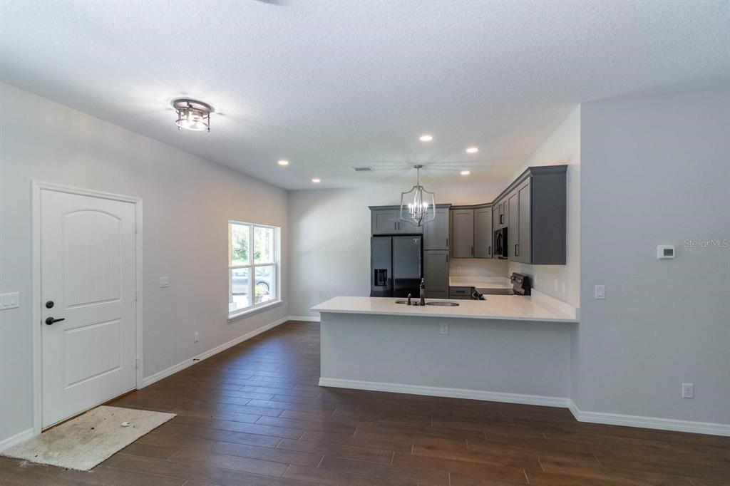 A dining area features wood-look tile flooring, a pendant light, and glass patio doors — TBD Lot 18 APAWAMIS DRIVE, SORRENTO, FL