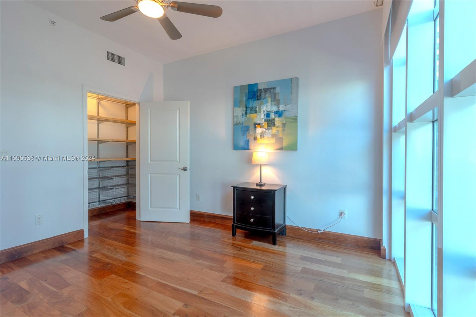 A bedroom features hardwood floors, a walk-in closet, a ceiling fan, and a nightstand — 1945 S Ocean Dr # M5, Hallandale Beach FL 33009, HALLANDALE BEACH, FL