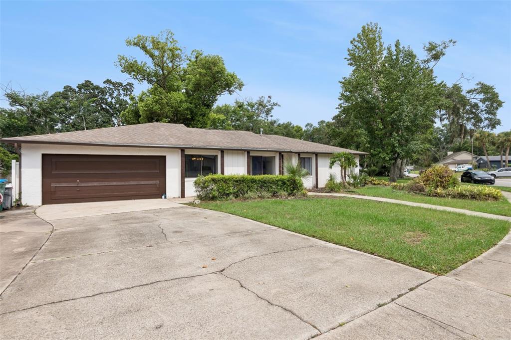 A single-story house with a brown garage door, white siding, and a concrete driveway — 971 WAVERLY DRIVE, LONGWOOD, FL