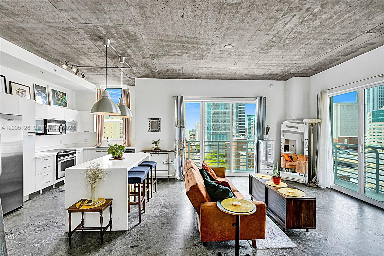 An open-concept living room and kitchen feature a concrete ceiling, concrete floors, and city views — 133 NE 2nd Ave # 1013, Miami FL 33132, MIAMI, FL
