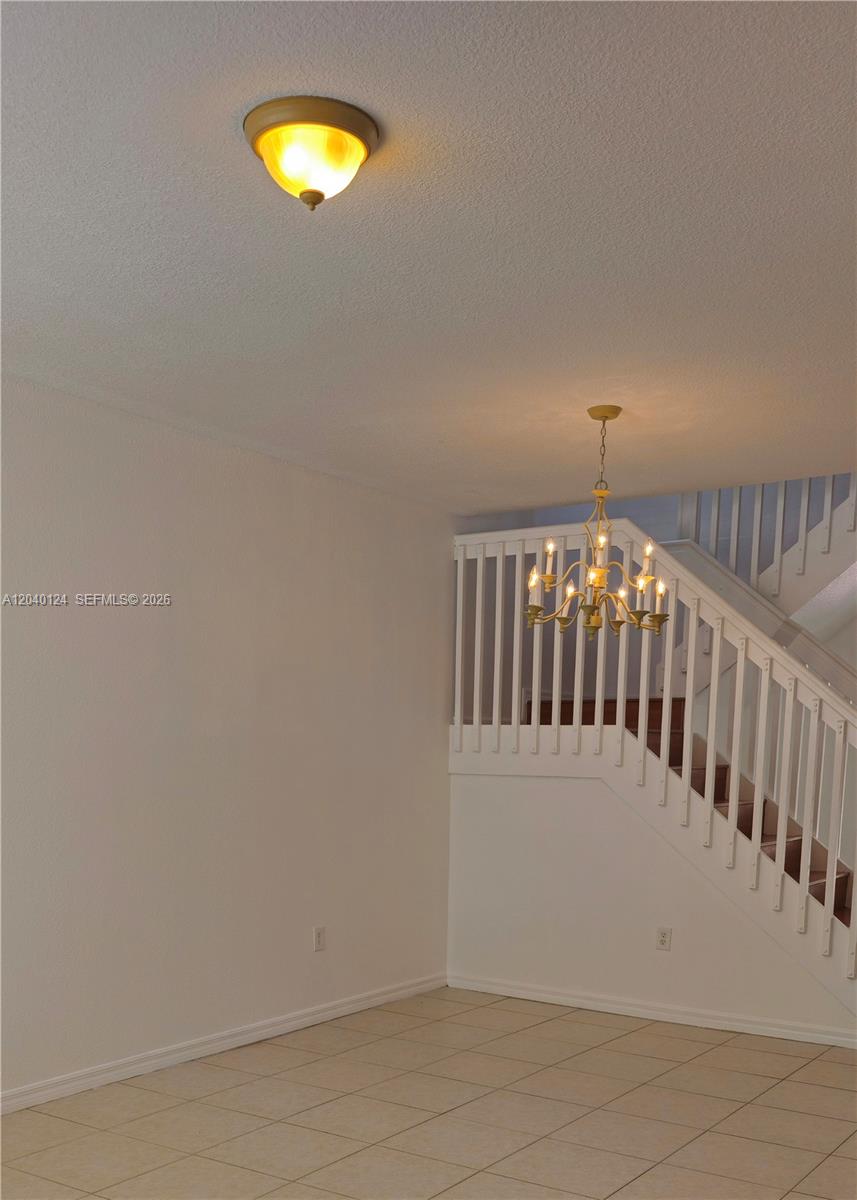 An interior view shows a tiled room with a staircase and two light fixtures — 2410 SW 153rd Pass, Miami FL 33185, MIAMI, FL