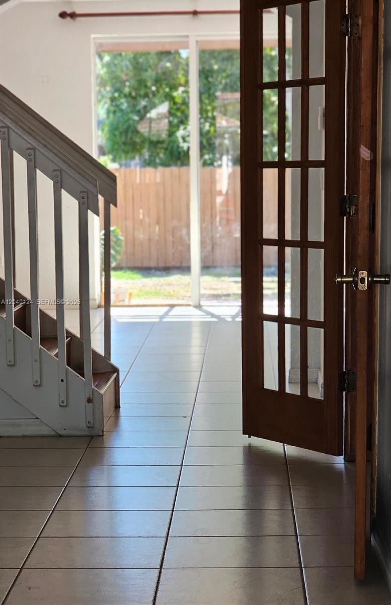 A view from a doorway showing a staircase and a glass door leading outside — 2410 SW 153rd Pass, Miami FL 33185, MIAMI, FL