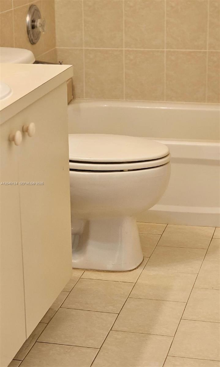 A white toilet sits next to a vanity in a tiled bathroom — 2410 SW 153rd Pass, Miami FL 33185, MIAMI, FL