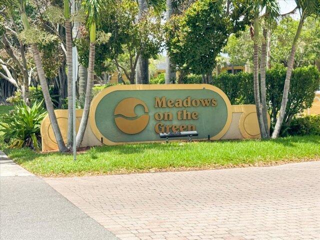 A sign for Meadows on the Green stands in a landscaped area with palm trees — 1104 Meadows Circle, Boynton Beach FL 33436, BOYNTON BEACH, FL