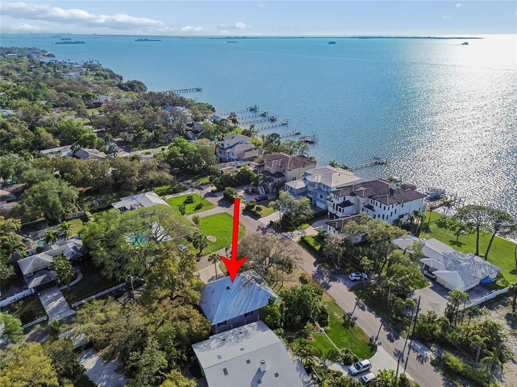 An aerial view shows a residential neighborhood with houses near a large body of water — 600 N MAYO STREET, CRYSTAL BEACH, FL