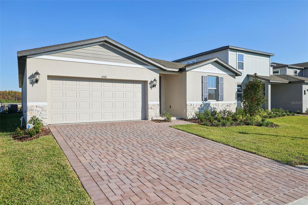 A two-story suburban house features a paved driveway, a two-car garage, and stone accents — 4505 EAGLE PERCH COURT, ST CLOUD, FL