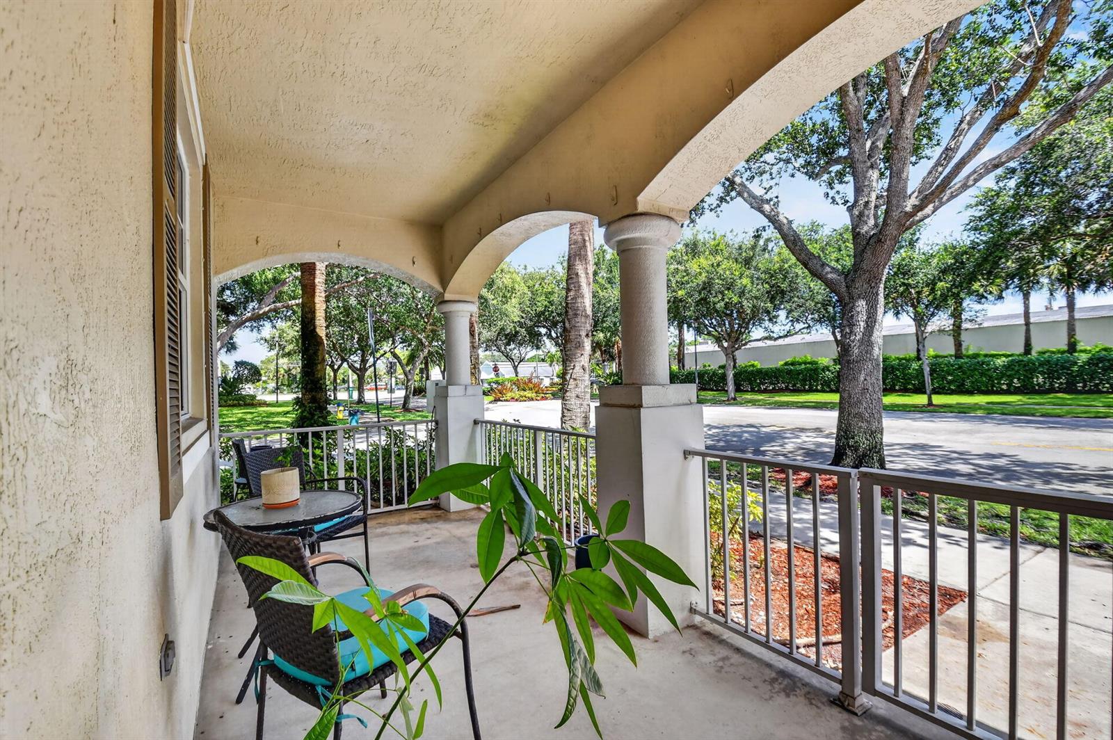 A covered porch features arched openings, concrete flooring, metal railings, and outdoor seating — 4816 W Bexley Park Drive # C, Delray Beach FL 33445, DELRAY BEACH, FL
