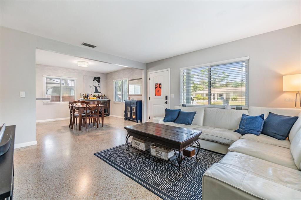 A living room with a white sectional sofa, coffee table, and an adjacent dining area — 2808 W LAKE AVENUE, TAMPA, FL