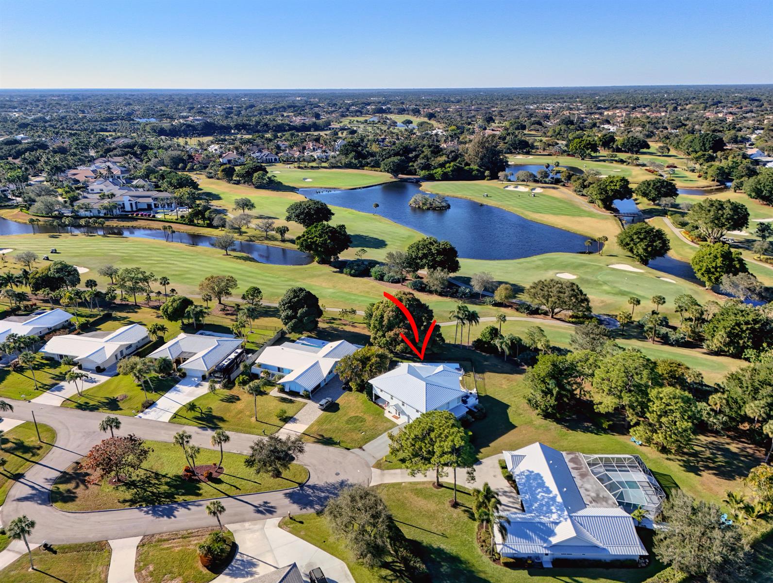An aerial view shows a residential neighborhood with houses situated along a golf course — 10355 Seagrape Way, Palm Beach Gardens FL 33418, PALM BEACH GARDENS, FL