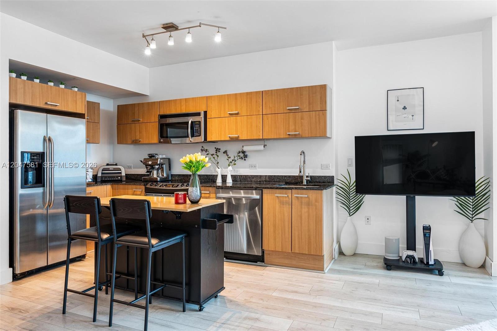A modern kitchen features light wood cabinets, stainless steel appliances, and a dark kitchen island — 350 S Miami Ave # 2108, Miami FL 33130, MIAMI, FL