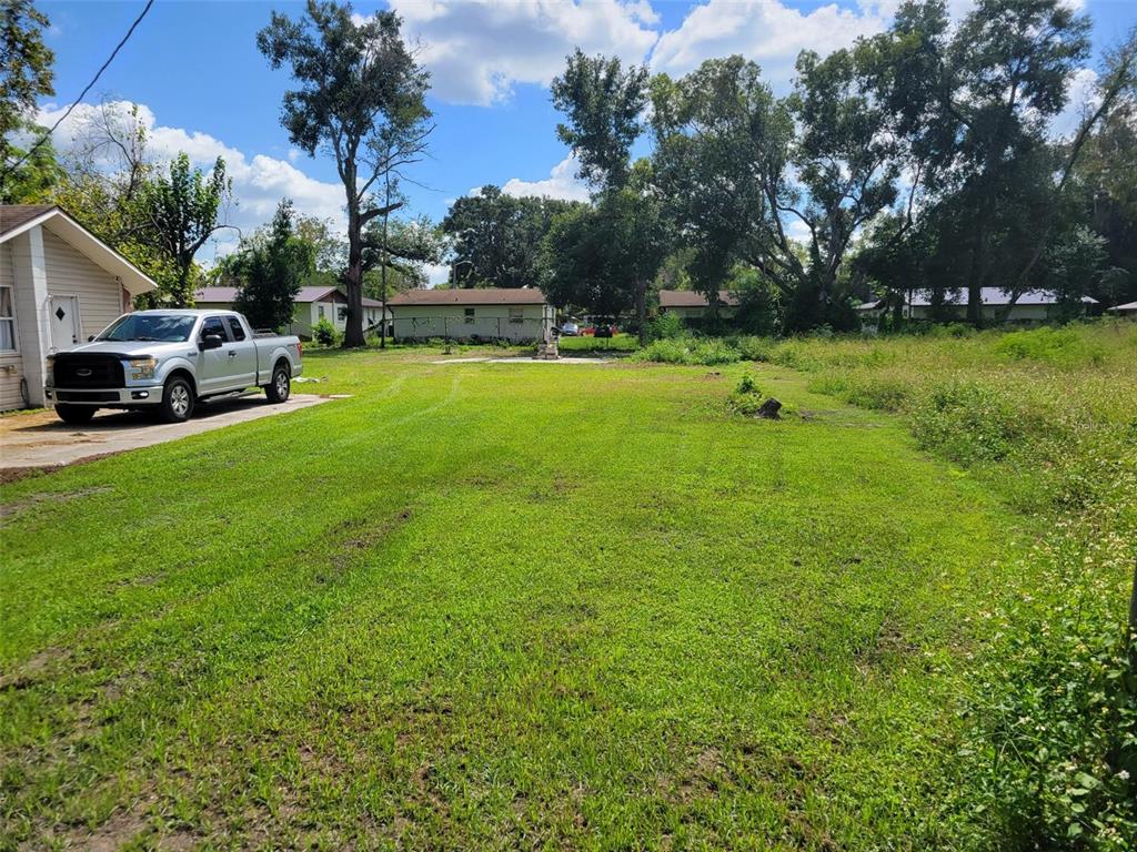 A silver pickup truck is parked on a concrete driveway next to a grassy lot — 38606 CALUMET AVENUE, ZEPHYRHILLS, FL