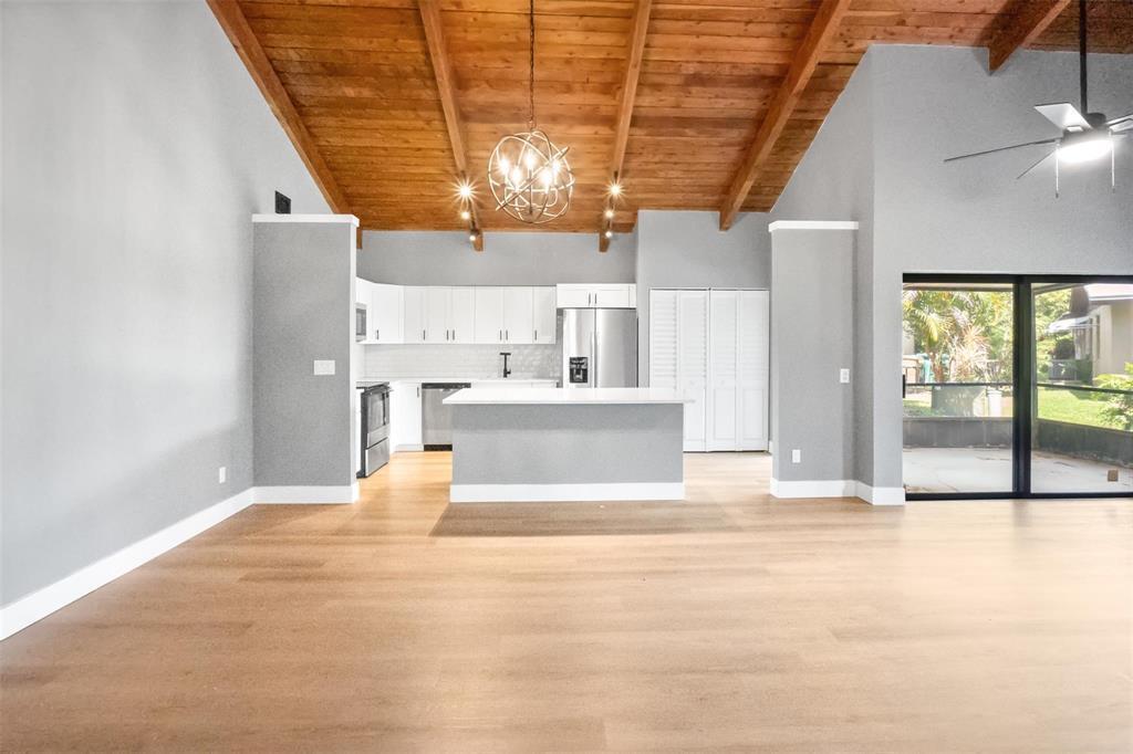 A kitchen with white cabinets and a center island sits under a wood-beamed ceiling — 2146 Nova Village Drive, Davie FL 33317, DAVIE, FL