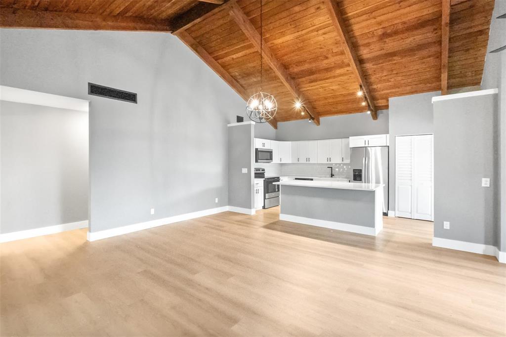 A kitchen with white cabinets and stainless steel appliances sits under a vaulted wood ceiling — 2146 Nova Village Drive, Davie FL 33317, DAVIE, FL