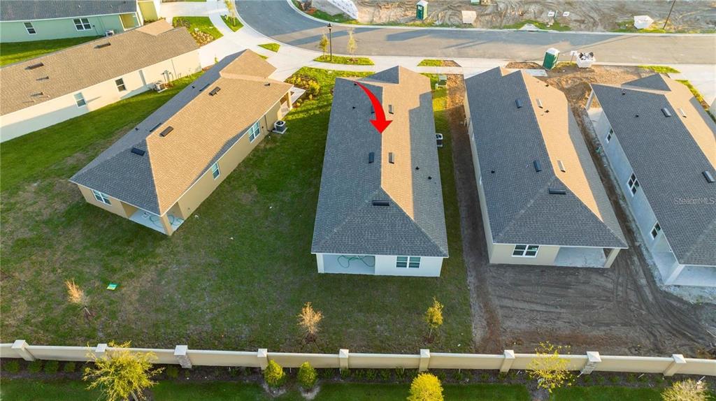 An aerial view shows the roof of a house with a red arrow pointing downward — 1779 POST OAK DRIVE, DAVENPORT, FL