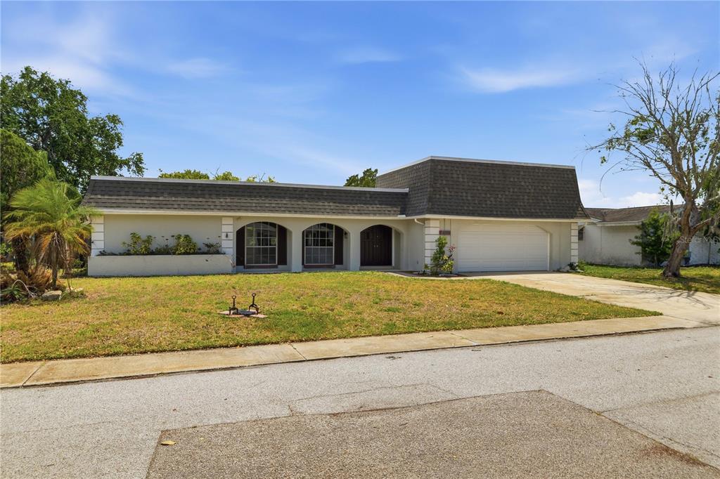 A single-story house with a mansard roof, arched windows, and an attached two-car garage — 4018 CASHMERE DRIVE, NEW PORT RICHEY, FL