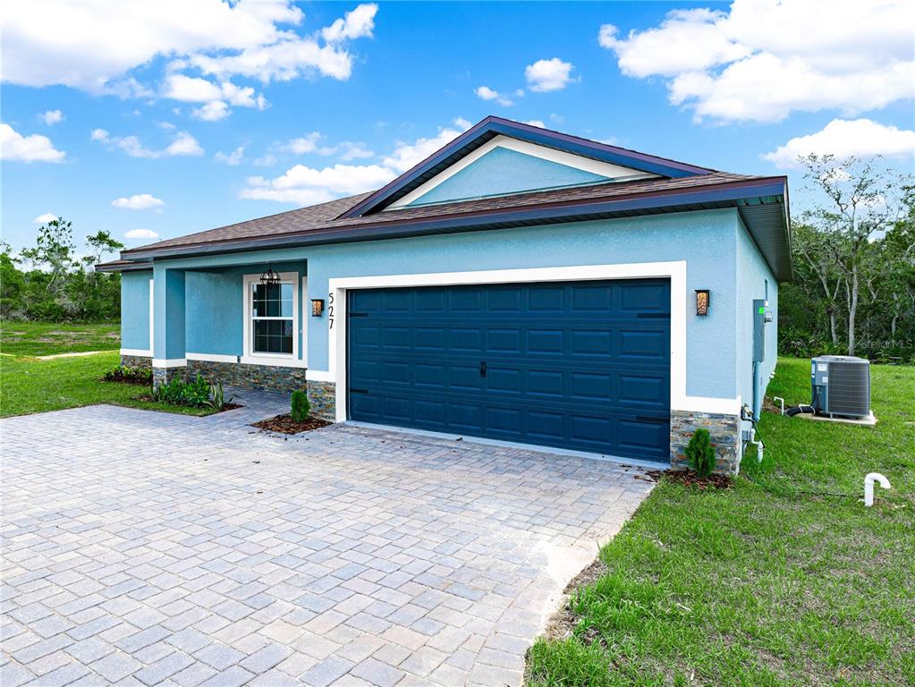 A blue single-story house with a two-car garage and a paved driveway — 47 ORCHID COURT, POINCIANA, FL