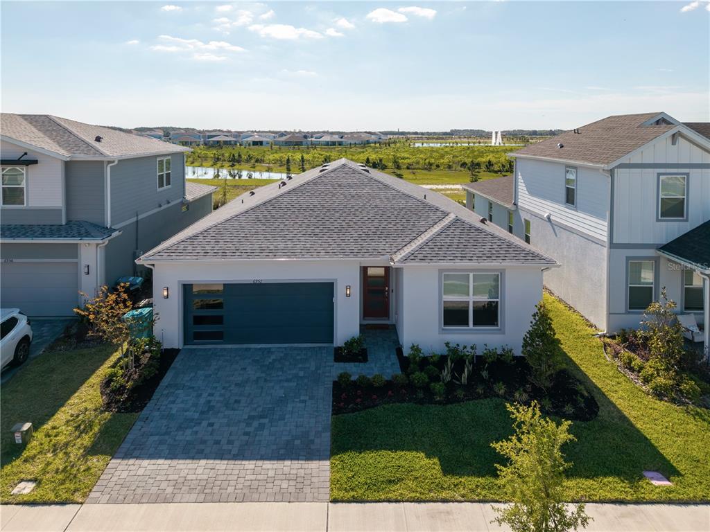 A single-story suburban house with a gray roof, white exterior, and a paved driveway — 6952 ROSY SKY AVENUE, ORLANDO, FL