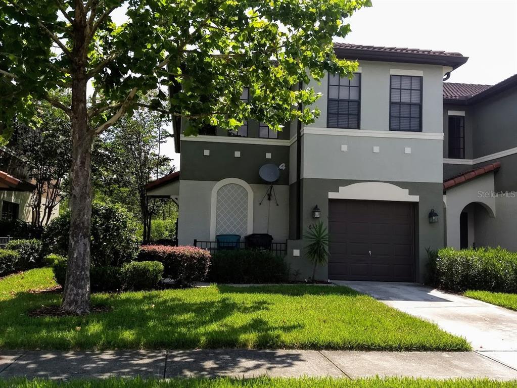 A two-story townhouse with a brown garage door and a green and gray exterior — 6133 APOLLOS CORNER WAY, ORLANDO, FL