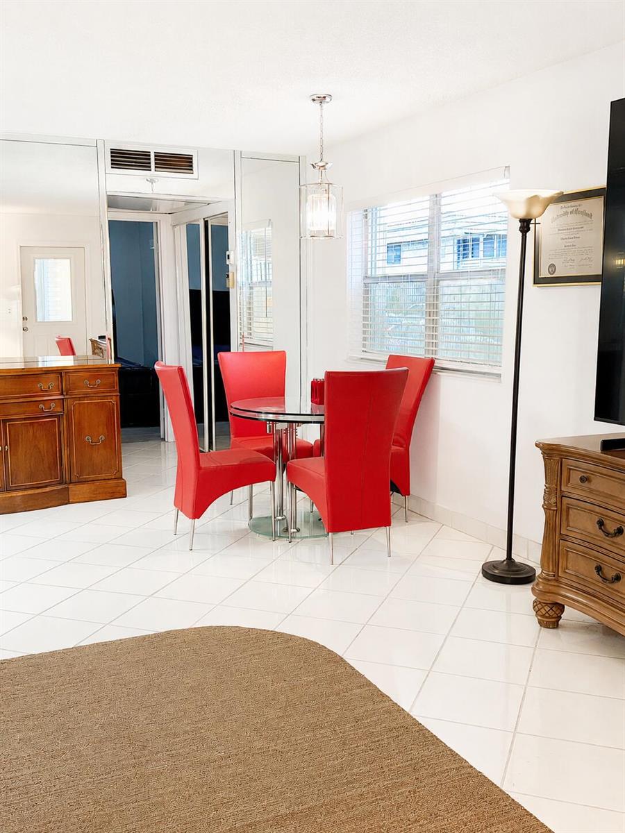 A dining area features a glass table with four red chairs on white tile flooring — 6 Brittany A # 6a, Delray Beach FL 33446, DELRAY BEACH, FL