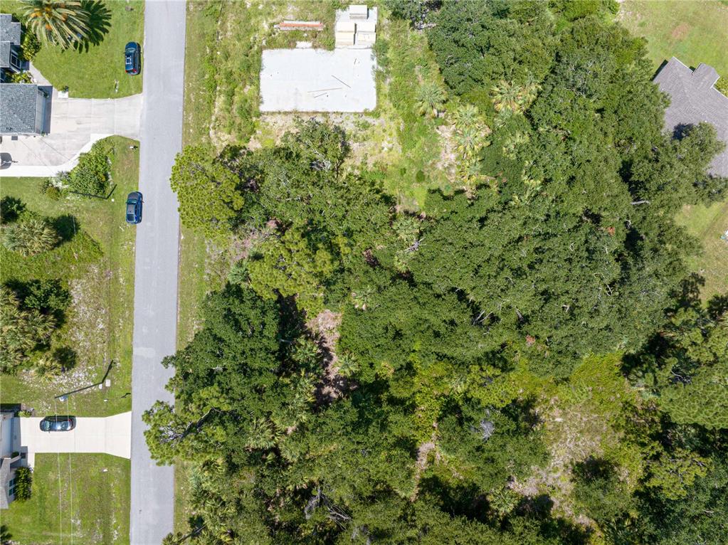 An aerial view shows a wooded residential lot with a concrete foundation slab — POMONA AVENUE, NORTH PORT, FL