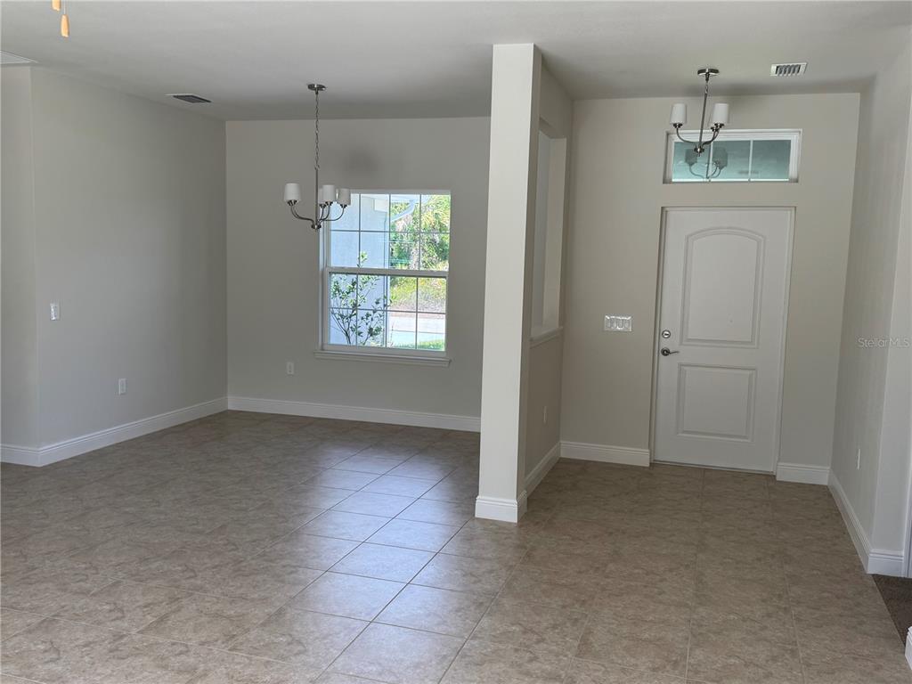 An entryway and dining area with tile flooring, neutral walls, and two hanging light fixtures — 3462 SERNICE STREET, NORTH PORT, FL