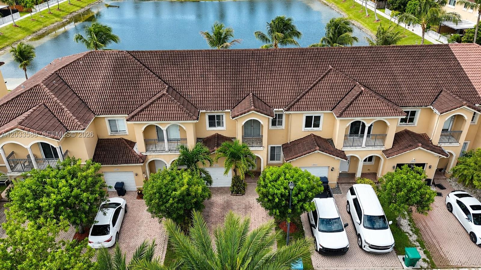 An aerial view of a multi-unit townhouse complex with a lake in the background — 16590 SW 70th St, Miami FL 33193, MIAMI, FL