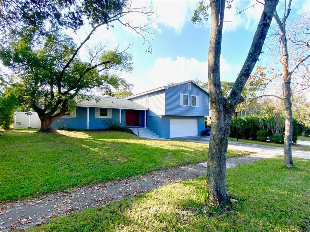 A blue two-story house with a white garage door sits on a grassy lot — 626 ORCHID LANE, ALTAMONTE SPRINGS, FL