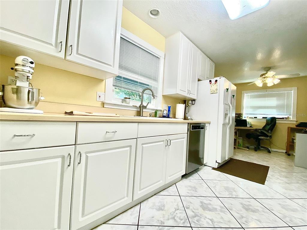 A kitchen features white cabinets, light countertops, a stainless steel dishwasher, and tiled flooring — 626 ORCHID LANE, ALTAMONTE SPRINGS, FL