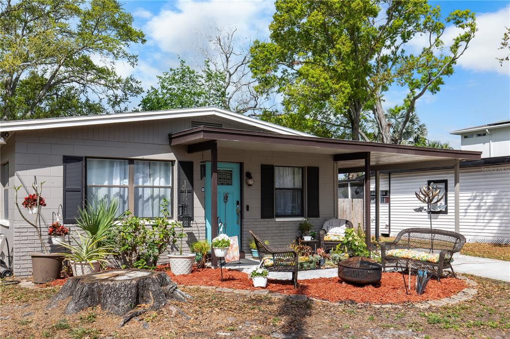 A single-story house with a teal front door, a covered porch, and a landscaped yard — 7009 S FITZGERALD STREET, TAMPA, FL