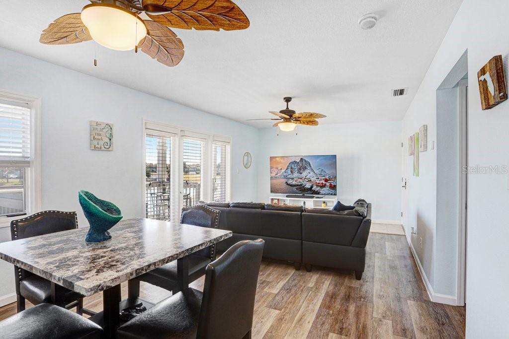A dining area with a marble table leads into a living room with a sectional sofa — 4714 COBIA DRIVE SE UNIT C, ST PETERSBURG, FL